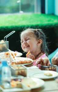 Image of child at dining table with food on table