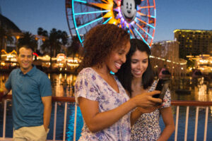 2 girls on their mobile phone inside Disney California Adventure Park - image
